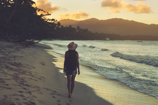 Traveler Girl Walking On Tropical Beach In Sunset. Vintage Photo